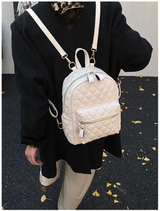 Détail du mini sac à dos blanc matelassé avec fermetures éclair dorées et surpiqûres
