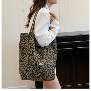 Detailed close-up of leopard print canvas tote bag featuring an oval blue brand label