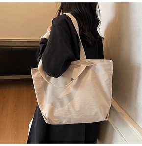 Détail du sac cabas en toile avec bouton pression en métal et large bandoulière