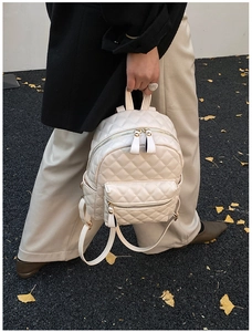 Détail du sac à dos matelassé blanc crème avec fermeture éclair dorée et motif losange