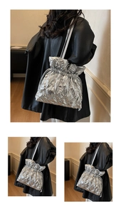 Detail shot of the silver quilted drawstring bag featuring a shiny metallic finish