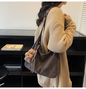 Gros plan du grand sac cabas marron foncé avec charm d'ours en peluche et pompon tissé