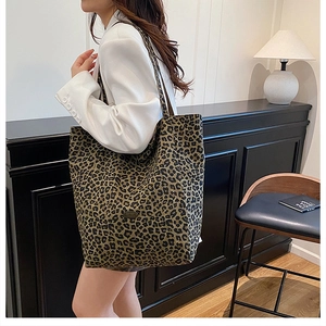 Detail of a large leopard print canvas tote bag carried by a model in a retro setting