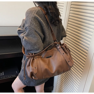 Detailed view of brown lychee texture tote with drawstring side and wide shoulder strap