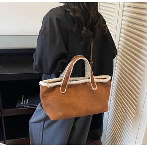 Brown suede underarm bag with white sherpa trim detail shown in a casual lifestyle setting