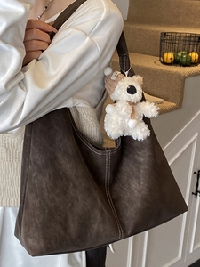Minimalist large brown hobo tote with white contrast stitching and a plush bear charm