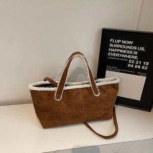 Close-up of brown suede shoulder bag featuring white faux fur trim and adjustable strap