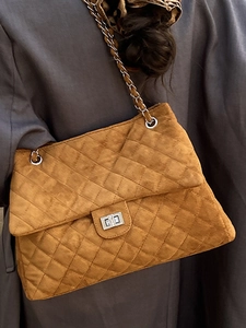 Sac fourre-tout matelassé caramel avec bandoulière chaîne porté par un mannequin