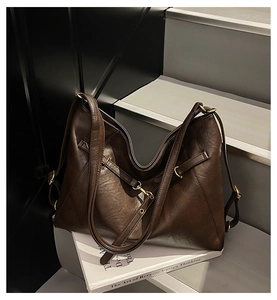 Détail du sac cabas en cuir marron foncé avec texture grainée et boucle en métal doré