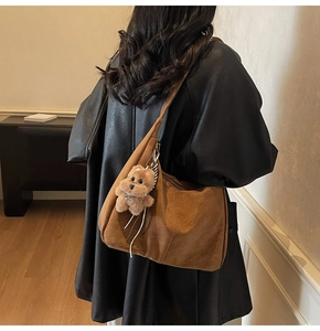 Vue détaillée du grand sac hobo marron foncé avec pendentif chien en peluche à l'épaule