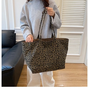Detailed view of leopard print canvas tote bag carried by model in a daily lifestyle setting