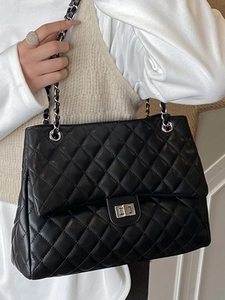 Sac fourre-tout noir matelassé avec bandoulière chaîne vue de profil sur mannequin