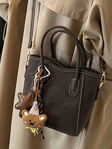 Minimalistische braune Beuteltasche mit Kontrastnähten und süßem Bärenanhänger