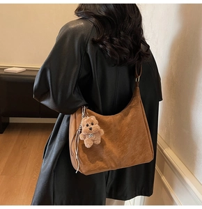 Détail du grand sac cabas en daim marron avec coutures et charm d'ours en peluche