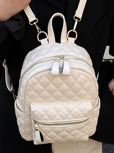 Sac à dos matelassé beige minimaliste avec motif en losanges et fermetures dorées