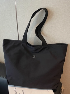 Sac fourre-tout noir minimaliste en nylon brillant avec logo circulaire et bandoulière