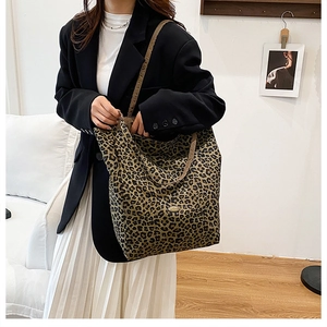 Detail shot of leopard print canvas tote bag with woven straps on a fashion model