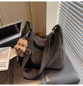 Détail d'un grand sac cabas marron foncé souple avec porte-clés chien en peluche