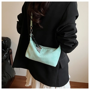 Detailed view of mint green matte shoulder bag with silver heart charm on model