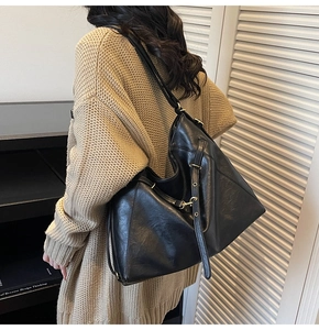 Détail du grand sac cabas noir en cuir avec texture lisse et bandoulière réglable