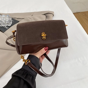 Détail d'un sac porté épaule marron avec mélange de daim et de cuir lisse