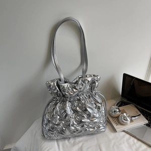 Detailed view of silver quilted drawstring tote bag with puffer texture and thin shoulder straps