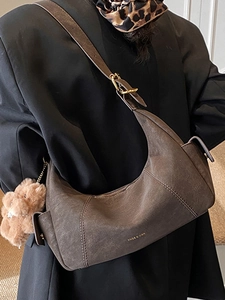 Retro faux suede crossbody crescent bag in deep brown with plush pendant and adjustable strap