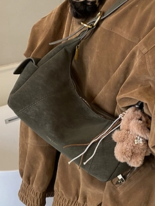 Olive green suede crescent hobo bag with plush dog charm and asymmetrical design