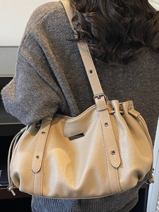 Chic beige pleated tote bag in lychee leather texture for women shown from the back