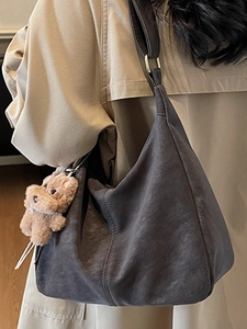Sac fourre-tout gris anthracite minimaliste avec accessoire chien sur un trench