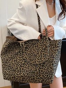 Large leopard print canvas tote bag with shoulder straps shown in a lifestyle pose