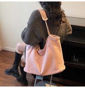 Pink suede-like tote bag shown on a model, highlighting large capacity and soft texture