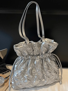 Metallic silver quilted drawstring shoulder bag with a rhombic pattern and soft padding