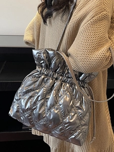 Quilted silver drawstring crossbody bag with metallic finish for winter casual fashion