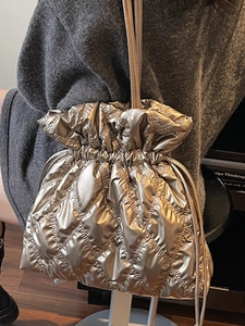Champagne gold quilted drawstring shoulder bag with a metallic finish and chic diamond pattern