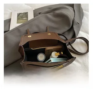 Vue détaillée du compartiment intérieur spacieux avec poche zippée du sac à dos en daim marron