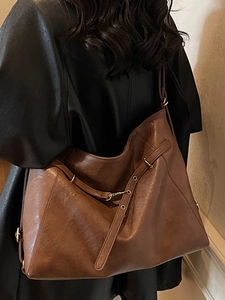 Grand sac fourre-tout rétro en cuir marron porté à l'épaule pour les déplacements