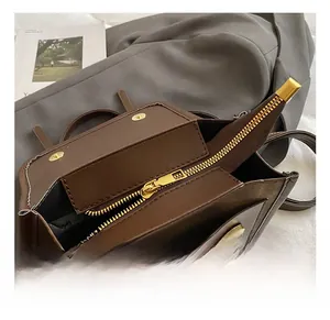 Détails du sac en cuir mat marron foncé avec fermeture éclair dorée et finitions métalliques