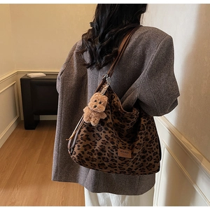 Vue détaillée du sac hobo en toile léopard avec breloque ours et sangle en cuir