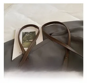 Détail du sac bandoulière vintage marron avec cuir dépoli et décoration de charm ours en peluche