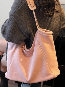 Pink minimalist suede large tote bag shown on shoulder in a stylish side view