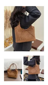 Detailed macro of vintage brown tote bag with bow tie knot and YMGONGZHU embossed logo