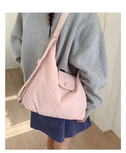 Pink nylon dumpling tote bag featuring a side pocket and adjustable wide strap detail