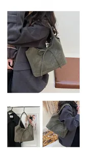 Close-up of olive green retro tote bag with bow tie knot and textured leather surface