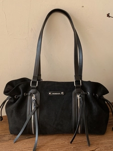 Large black suede tote bag with fringe zippers and minimalist shoulder strap design