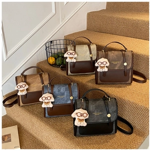 Vue détaillée des sacs à dos bicolores en daim avec empiècements en cuir et porte-clés peluche