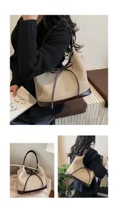 Detail view of large tote bag with bow accent and embossed VV GONGZHU lettering