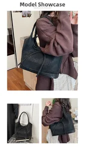 Detail of black tote bag with V GONGZHU embossed logo and textured matte finish