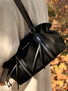Black suede tote bag with drawstring closure and leather straps for casual commuting