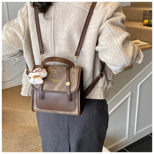 Détail de la texture du sac à dos en daim marron avec charmant petit ours en peluche